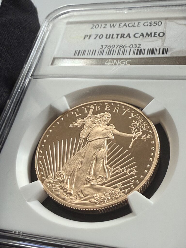 USA 2012 American Gold Eagle 1 oz Proof in NGC slab PF70 UCAM; oblique view of the reverse with eagle family and NGC hologram visible at the bottom.