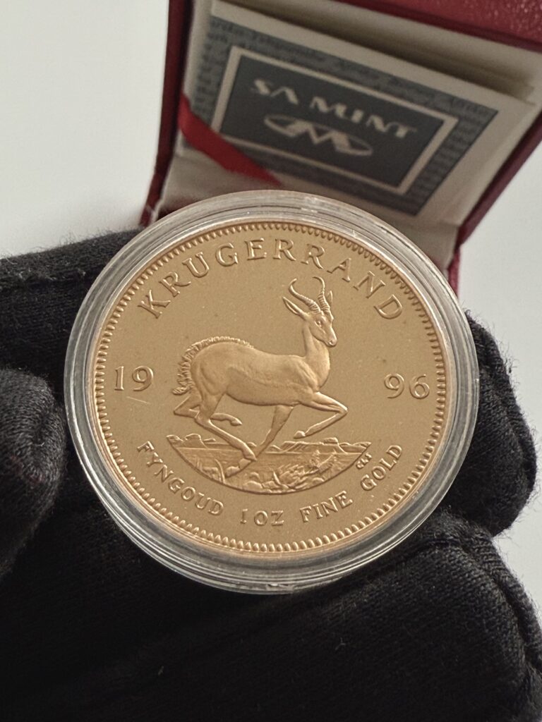 Krugerrand 1996 1 oz Gold Proof in a transparent capsule; obverse with a portrait of Paul Kruger, alongside a certificate and red case from the South African Mint.