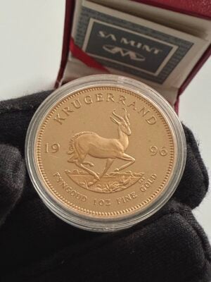 克鲁格兰 1996 年 1 盎司精制金,装在透明胶囊中;正面有保罗·克鲁格的肖像,旁边是南非造币厂的证书和红色表壳。