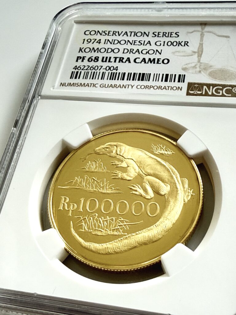 Indonesien 1974 100000 Rupiah Goldmünze Komodowaran im NGC-Holder PF68 Ultra Cameo, Revers mit Waranmotiv und Nennwert Rp100000, schräg fotografiert.