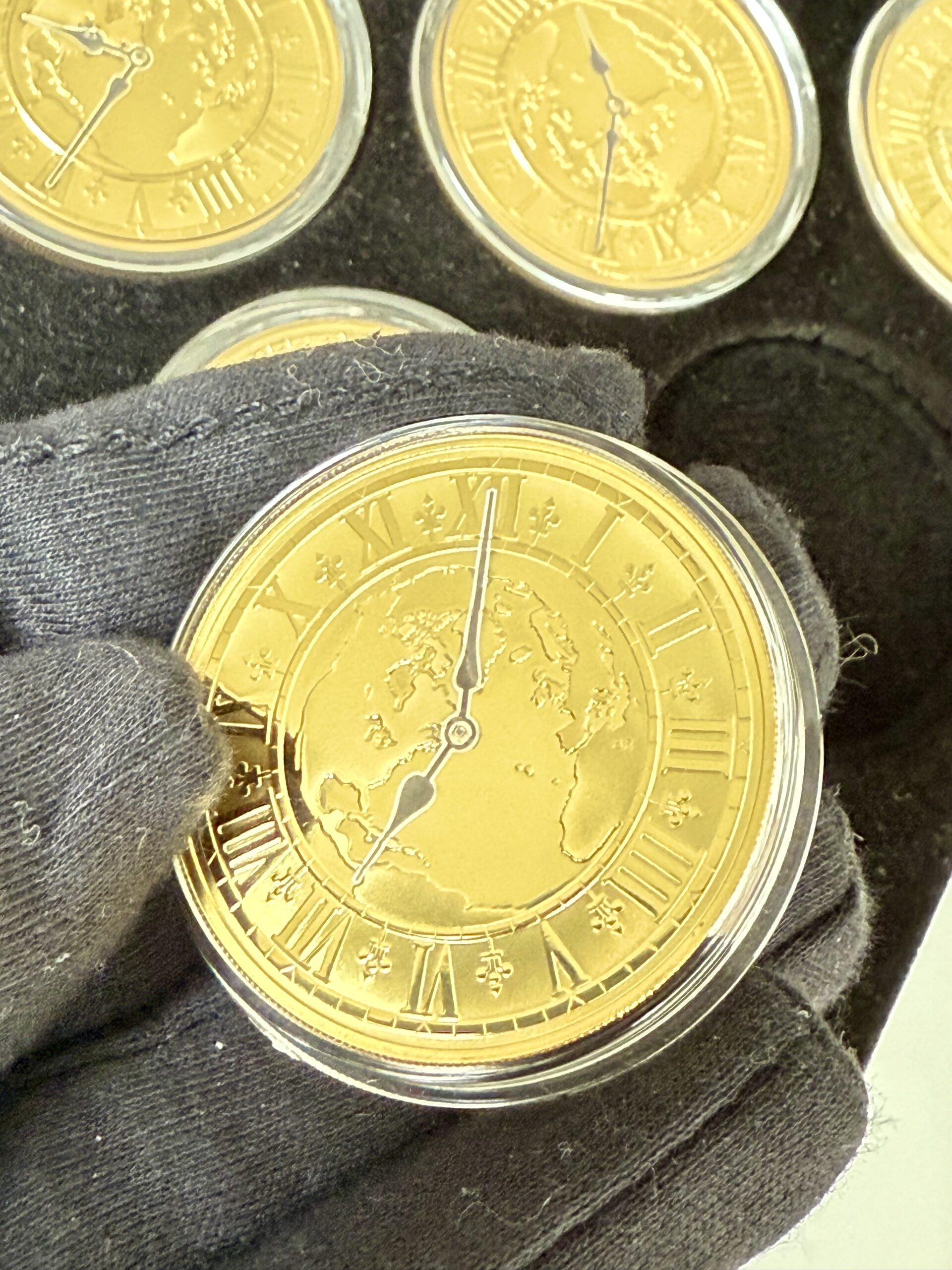 kanada-2005-300-dollar-zeitzonen-kanadas-5oz_11 Kanada 2005 Zeitzonen Kanadas Gold Proof Set – sechs 300-Dollar-Goldmünzen im geöffneten schwarzen Präsentationsetui, jede Münze gekapselt mit römischem Zifferblatt, Weltkarten-Motiv und unterschiedlichen Uhrzeiten auf schwarzer Velourseinlage.