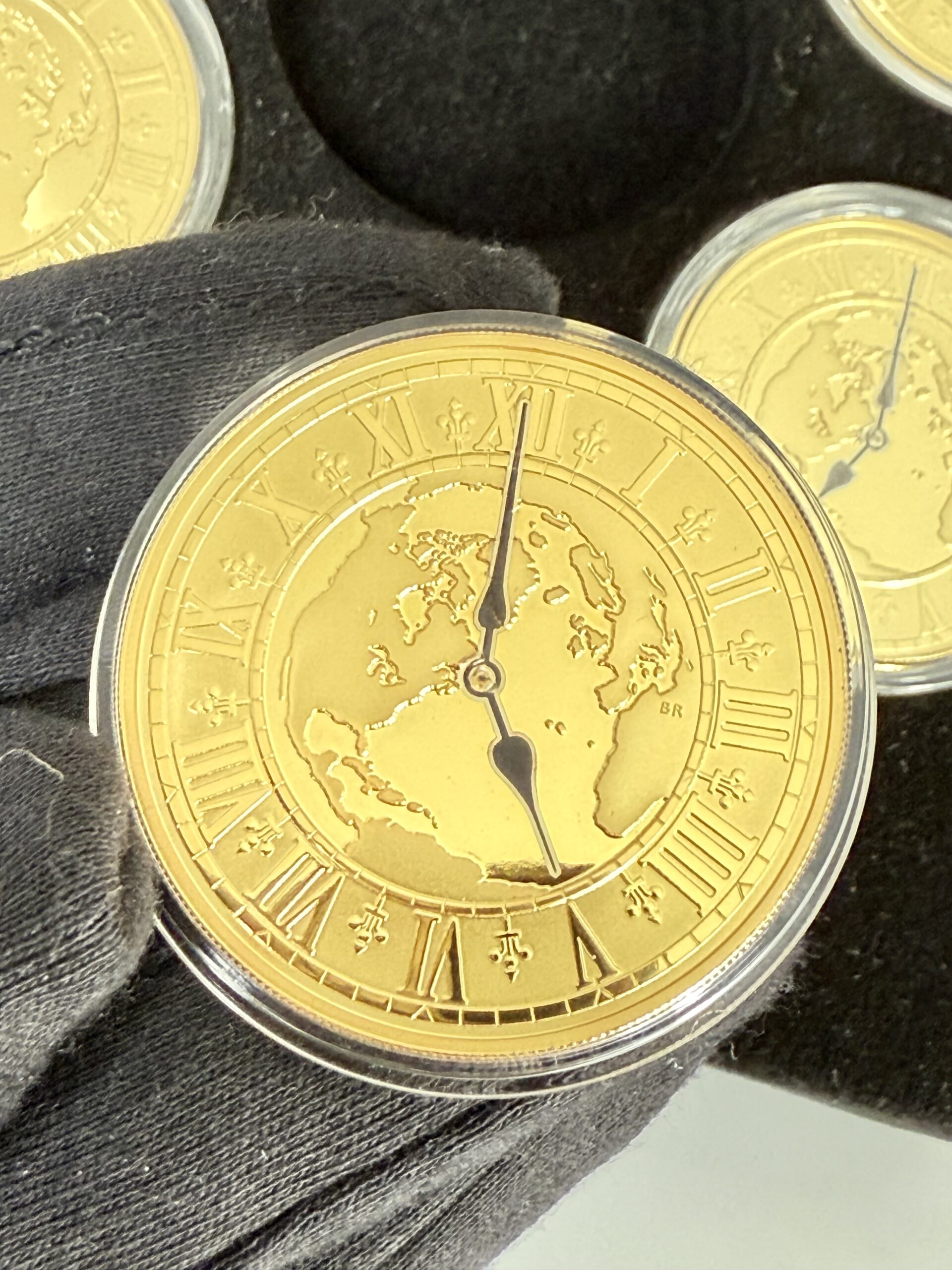 kanada-2005-300-dollar-zeitzonen-kanadas-5oz_13 Kanada 2005 Zeitzonen Kanadas Gold Proof Set – sechs 300-Dollar-Goldmünzen im geöffneten schwarzen Präsentationsetui, jede Münze gekapselt mit römischem Zifferblatt, Weltkarten-Motiv und unterschiedlichen Uhrzeiten auf schwarzer Velourseinlage.