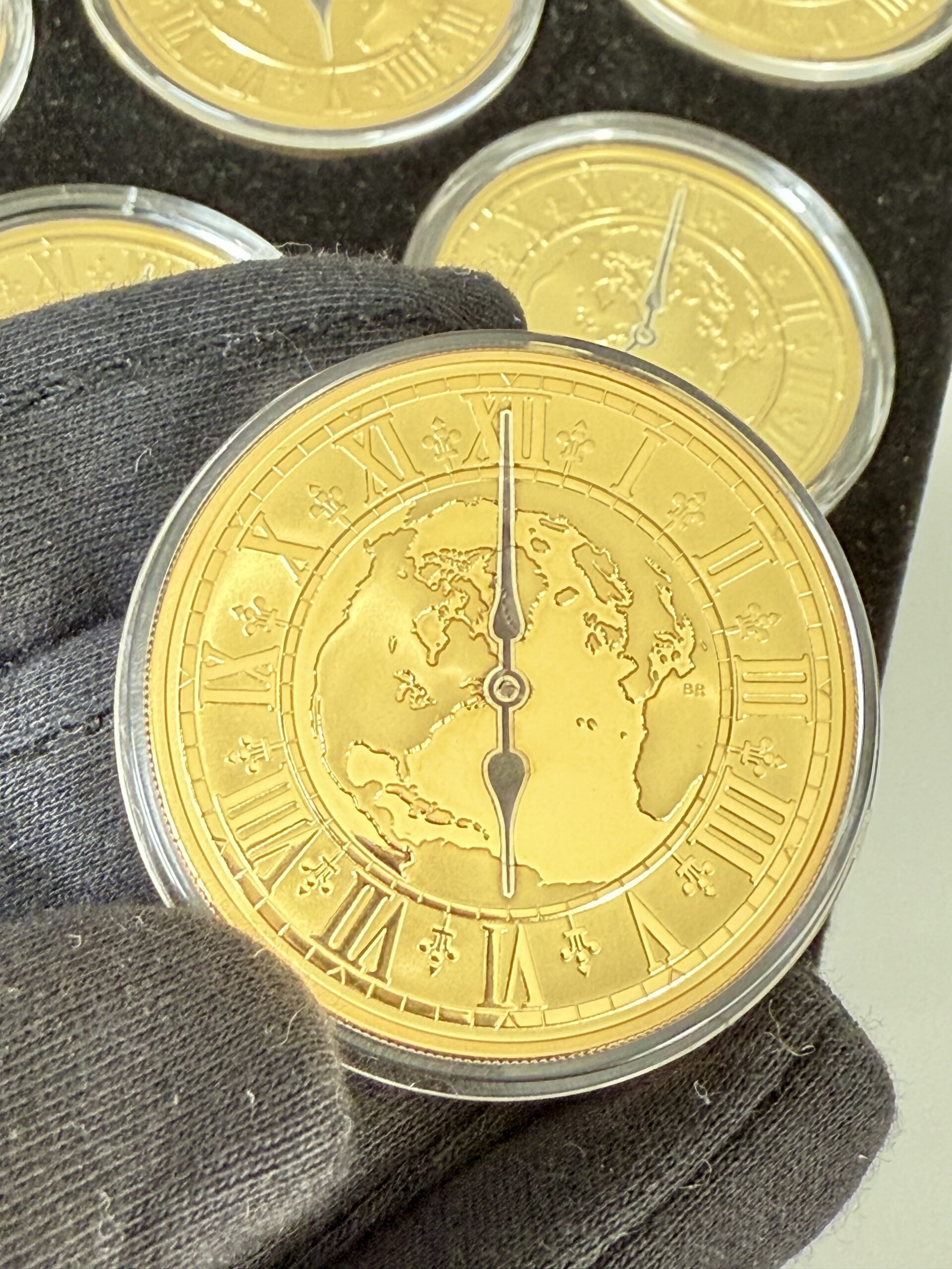 kanada-2005-300-dollar-zeitzonen-kanadas-5oz_7 Kanada 2005 Zeitzonen Kanadas Gold Proof Set – sechs 300-Dollar-Goldmünzen im geöffneten schwarzen Präsentationsetui, jede Münze gekapselt mit römischem Zifferblatt, Weltkarten-Motiv und unterschiedlichen Uhrzeiten auf schwarzer Velourseinlage.