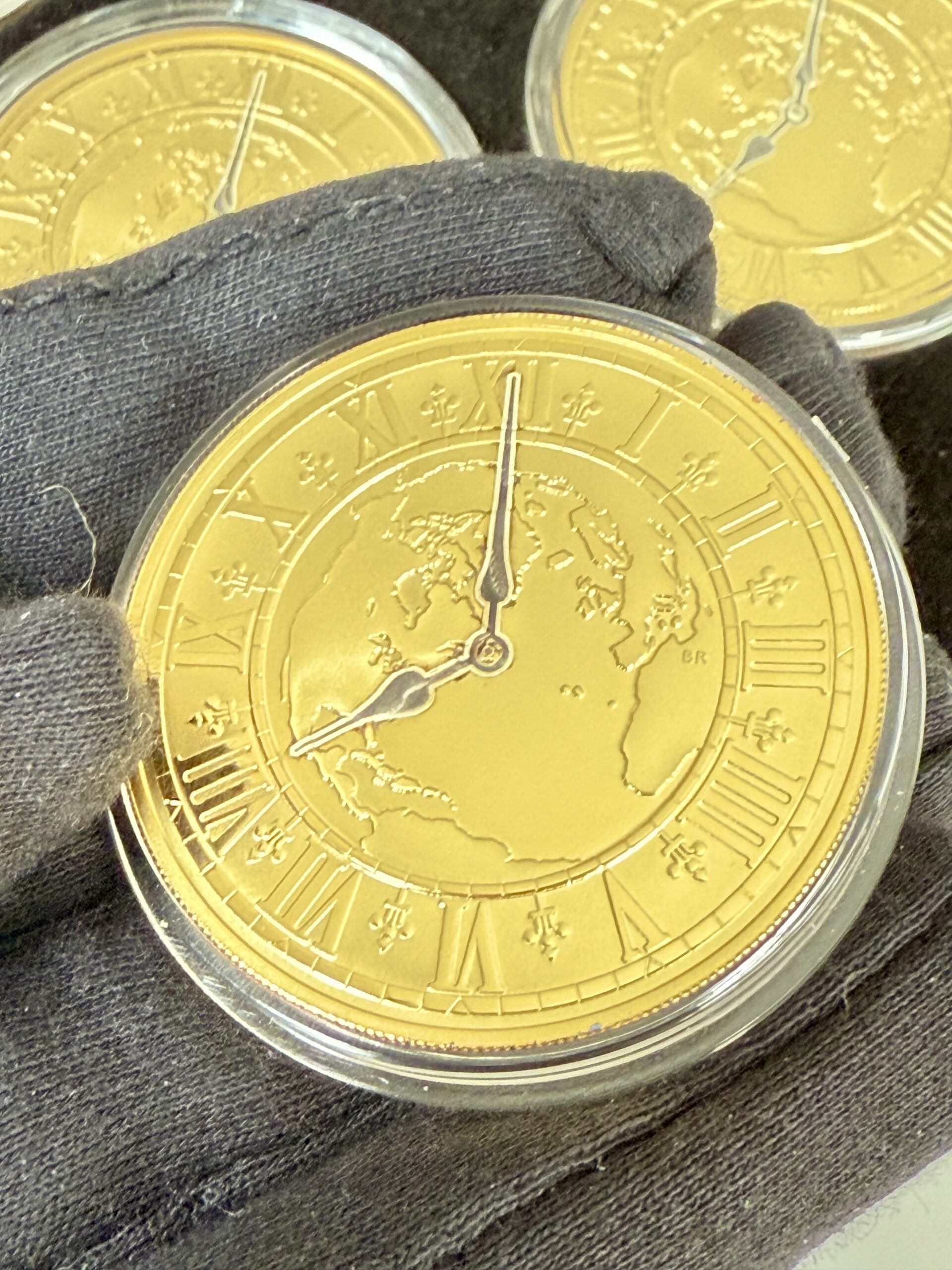 kanada-2005-300-dollar-zeitzonen-kanadas-5oz_8 Kanada 2005 Zeitzonen Kanadas Gold Proof Set – sechs 300-Dollar-Goldmünzen im geöffneten schwarzen Präsentationsetui, jede Münze gekapselt mit römischem Zifferblatt, Weltkarten-Motiv und unterschiedlichen Uhrzeiten auf schwarzer Velourseinlage.