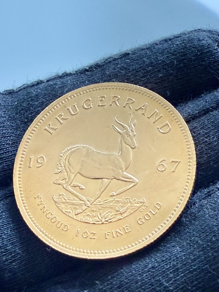 Moneta d'oro Krugerrand - dritto con ritratto di Paul Kruger e iscrizione circostante SUID-AFRIKA SOUTH AFRICA - tenuta con guanto