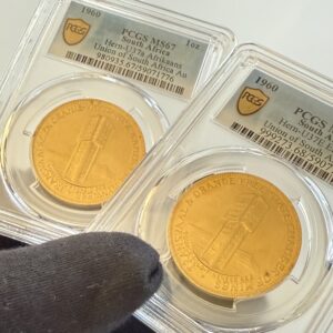 Zwei PCGS-Slabs nebeneinander mit Südafrika 1960 Chamber of Mines 1oz Gold. Links Afrikaans-Variante Hern-U37a PCGS MS67, rechts English-Variante Hern-U37b PCGS MS68, jeweils mit Turmmotiv.