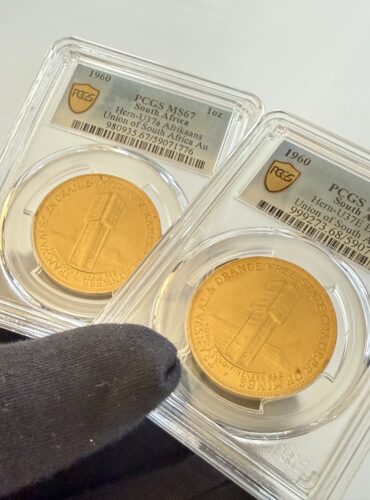 Zwei PCGS-Slabs nebeneinander mit Südafrika 1960 Chamber of Mines 1oz Gold. Links Afrikaans-Variante Hern-U37a PCGS MS67, rechts English-Variante Hern-U37b PCGS MS68, jeweils mit Turmmotiv.