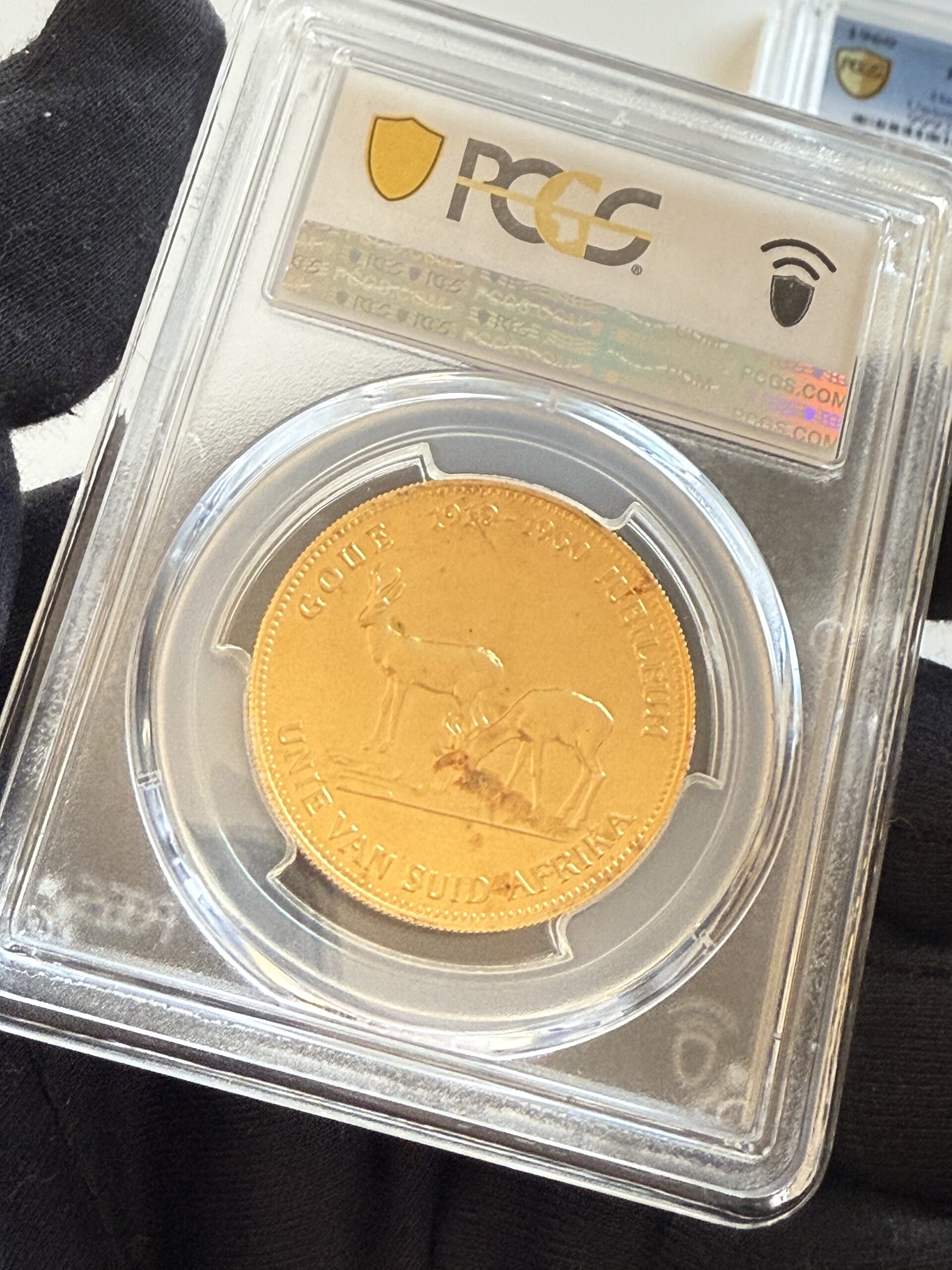 suedafrika-1960-chamber-of-mines-1oz-gold-afrikaans-und-englisch.pcgs_9 Südafrika 1960 Chamber of Mines 1oz Gold, Afrikaans-Version im PCGS-Holder MS67; Turm-Motiv mit umlaufender afrikaanssprachiger Legende, Label mit „Hern-U37a Afrikaans“.