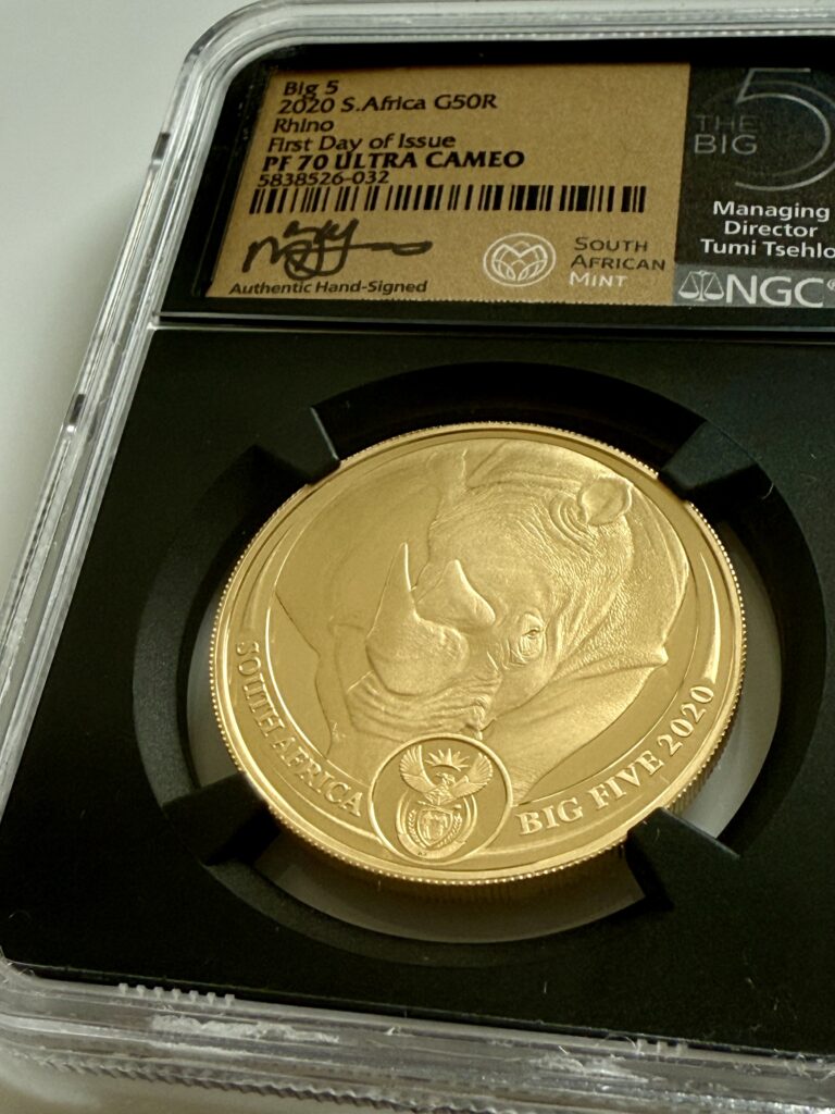 Südafrika 2020 Big Five Rhino 1oz Gold Proof im NGC-Holder PF70 Ultra Cameo, First Day of Issue, handsigniertes Label mit South African Mint Logo; Revers mit Nashornkopf, Wappenmedaillon, Umschrift SOUTH AFRICA und BIG FIVE 2020.