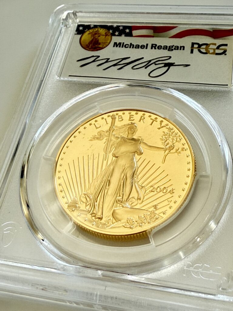 USA 2004 American Eagle 1oz Gold Proof 50 Dollars, Liberty mit Fackel und Olivenzweig, Jahr 2004 mit W-Mintmark, im PCGS-Holder mit Reagan Legacy Series Michael Reagan Signaturlabel, schräg fotografiert.
