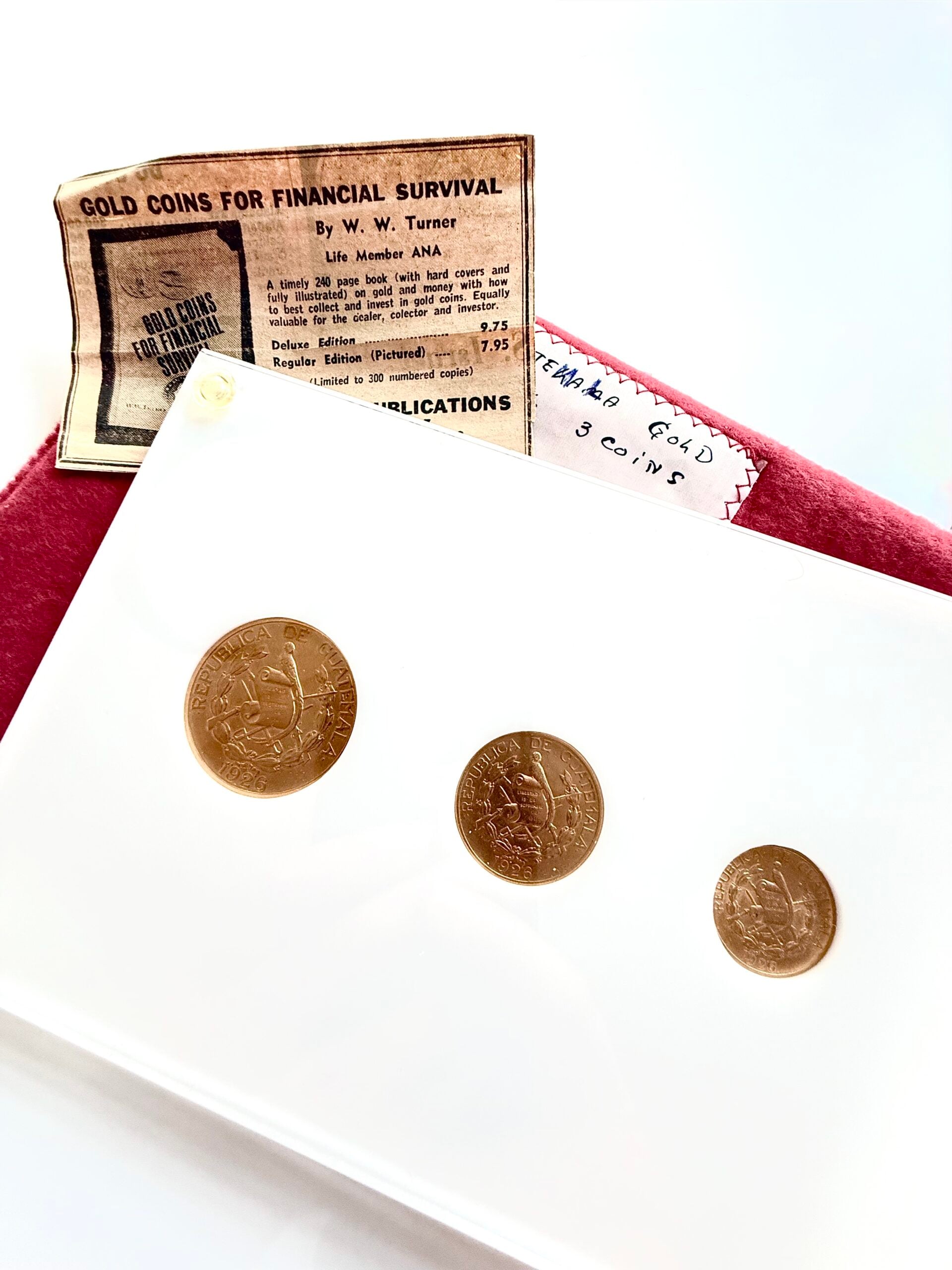 Juego de Quetzales de Oro de Guatemala 1926, 20 x 10 x 5, en estuche blanco con el lema "La Tierra de donde el Arcoíris obtiene su Color".