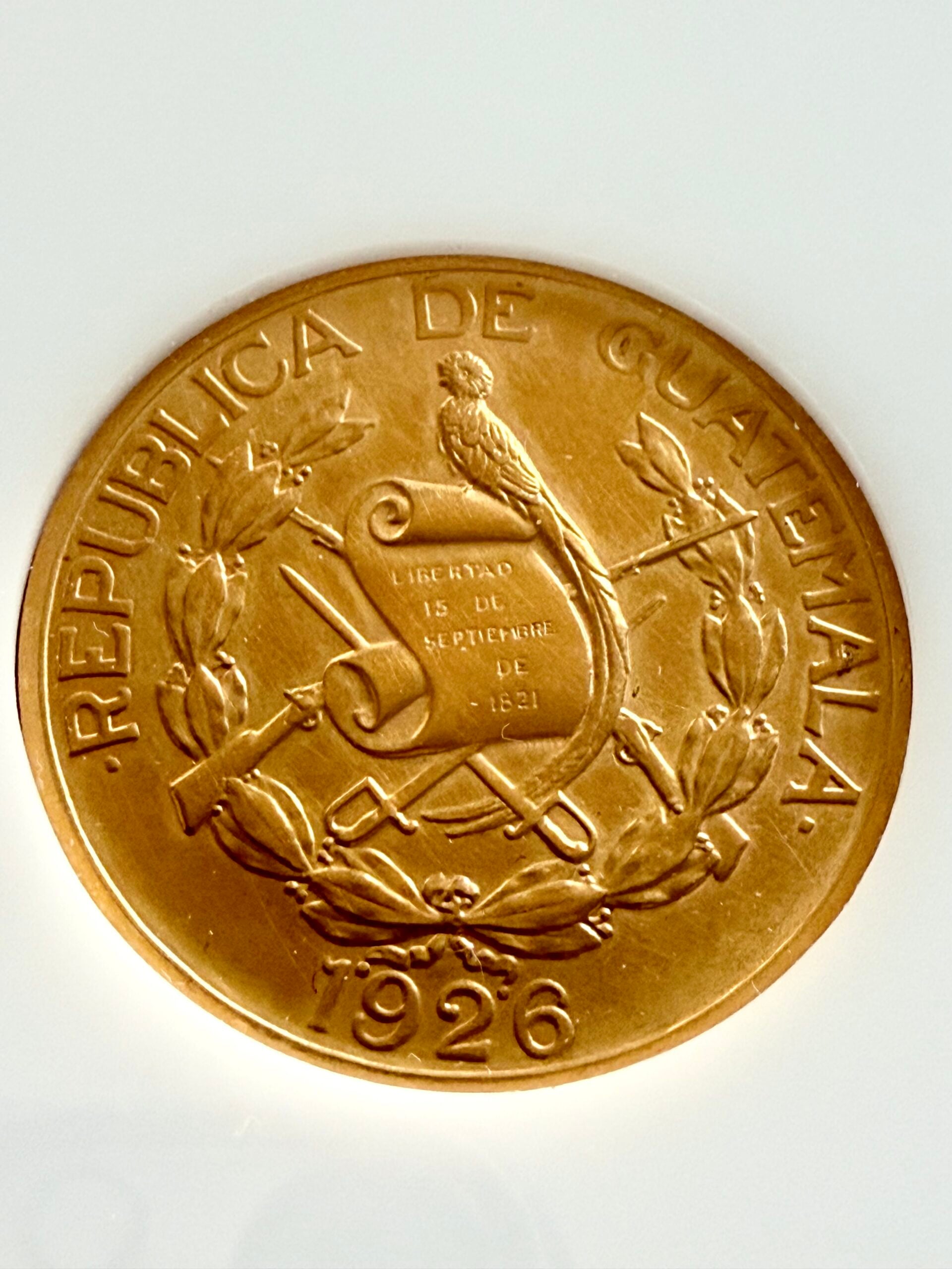Juego de Quetzales de Oro de Guatemala 1926, 20 x 10 x 5, en estuche blanco con el lema "La Tierra de donde el Arcoíris obtiene su Color".