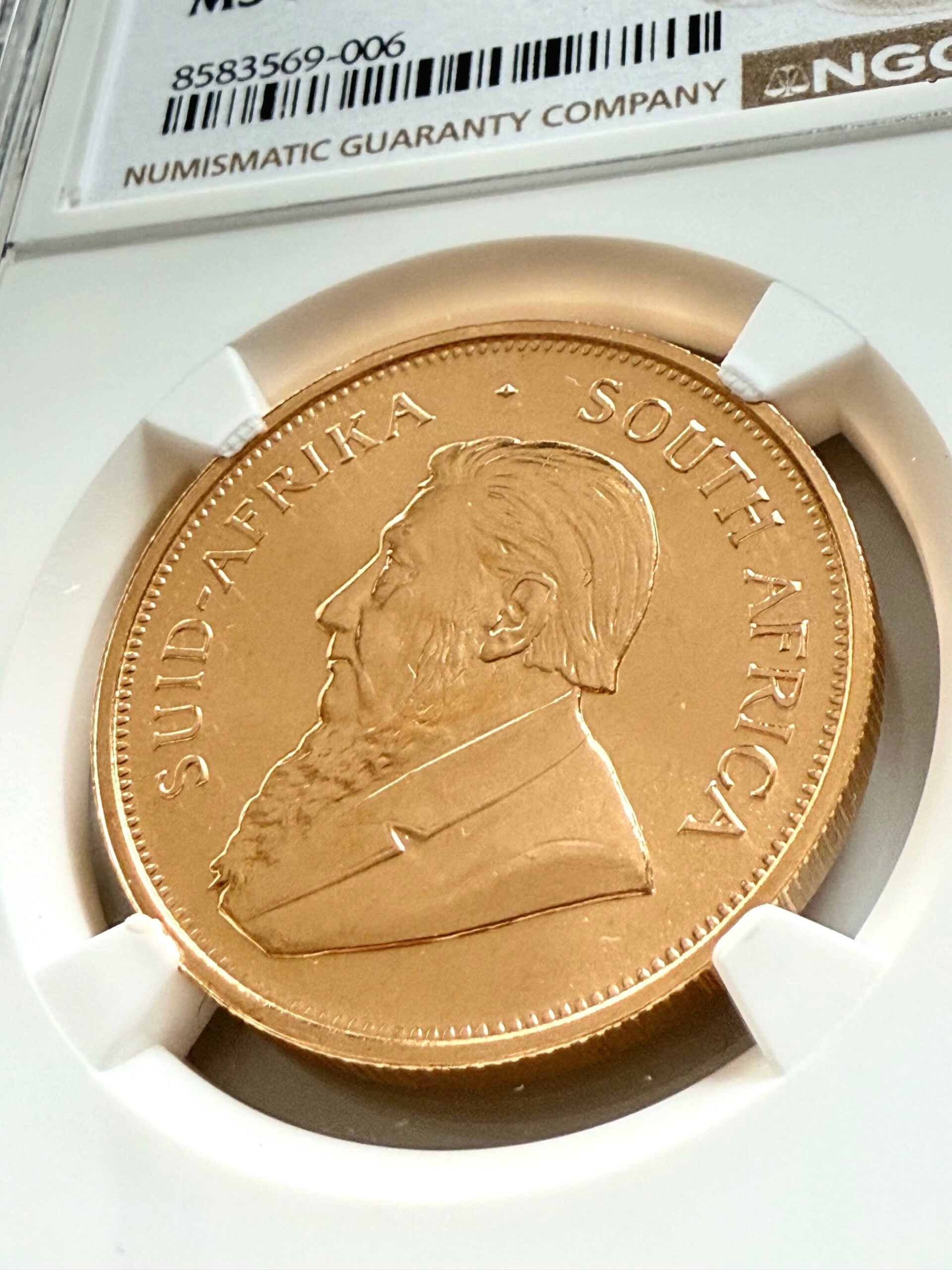Moneda sudafricana Krugerrand de 1 onza de oro de 1975 en estuche NGC MS67, anverso con retrato de Paul Kruger, certificado 8583569-006.