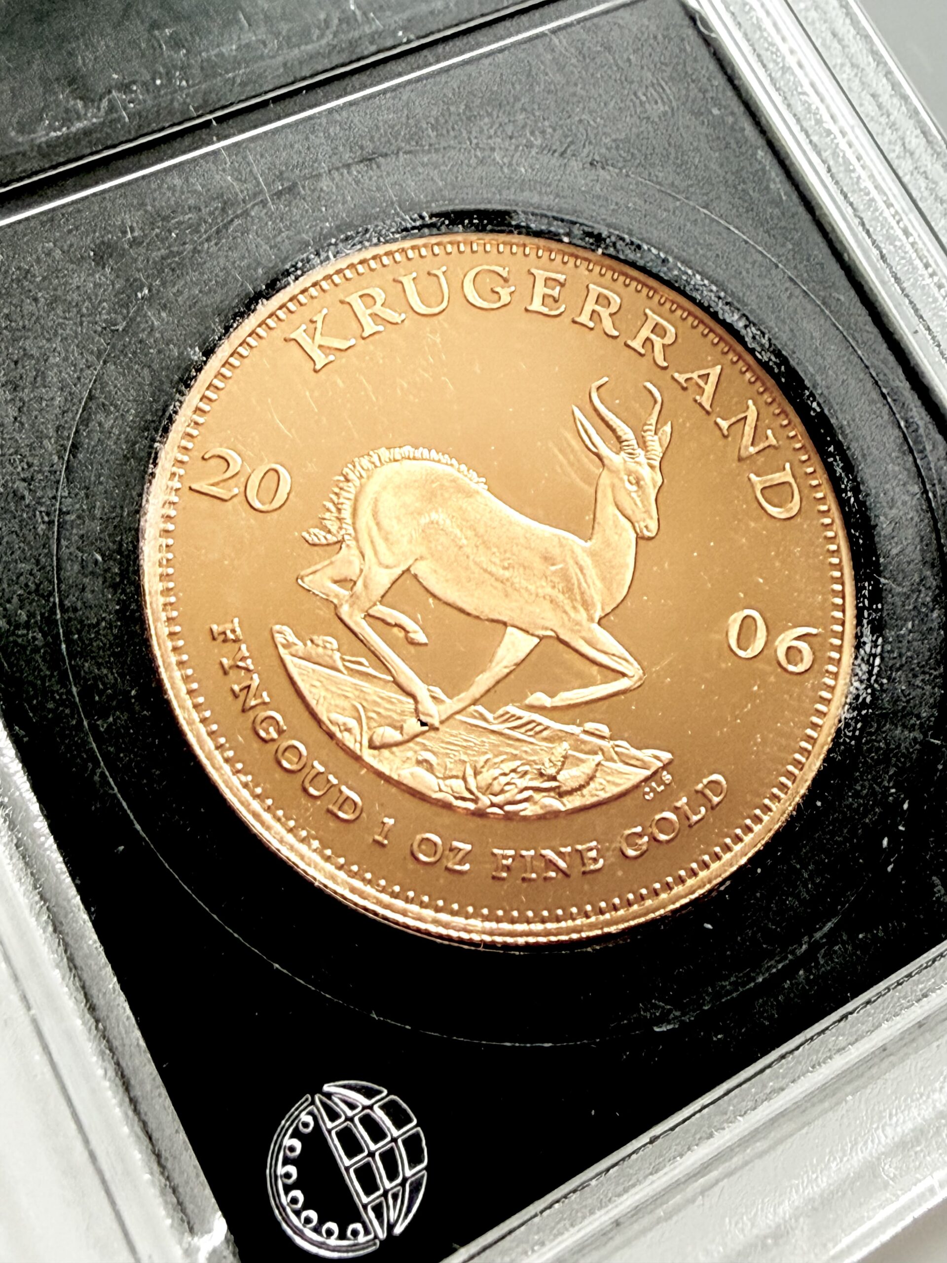 kruegerrand-2006-gold-1oz-certified-proof_3 Ein 2006 Krügerrand aus 1 Unze Gold in der Ausführung "Certified Proof", sicher verwahrt in einem originalen South African Mint (SAM) Slab. Im Hintergrund ist das dazugehörige Zertifikat der Münzstätte zu sehen.
