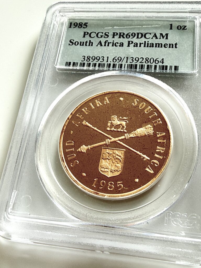 South Africa - 1985 Parliament - 1 oz Proof - PCGS PR69 DCAM - Cert 13928064 - Coin in PCGS slab with crossed parliamentary scepters and coat of arms