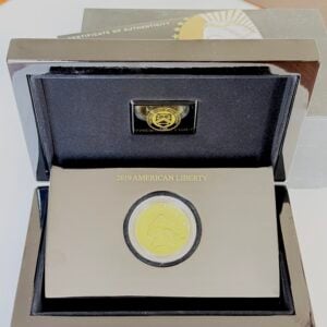 2019 American Liberty Goldmünze in geöffneter Präsentationsbox mit schwarzem Etui, eingesetzter Kapsel und teilweise sichtigem Echtheitszertifikat im Hintergrund.