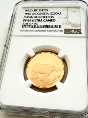 NGC-zertifizierte Goldmünze aus Indonesien von 1987 mit dem Motiv eines Javanischen Nashorns. Auf dem Label steht „Wildlife Series - 1987 Indonesia G200KR - Javan Rhinoceros - PF 69 Ultra Cameo“ mit der Zertifizierungsnummer 5785127-007. Die Münze ist in einem NGC-Slab auf weißem Hintergrund fotografiert.