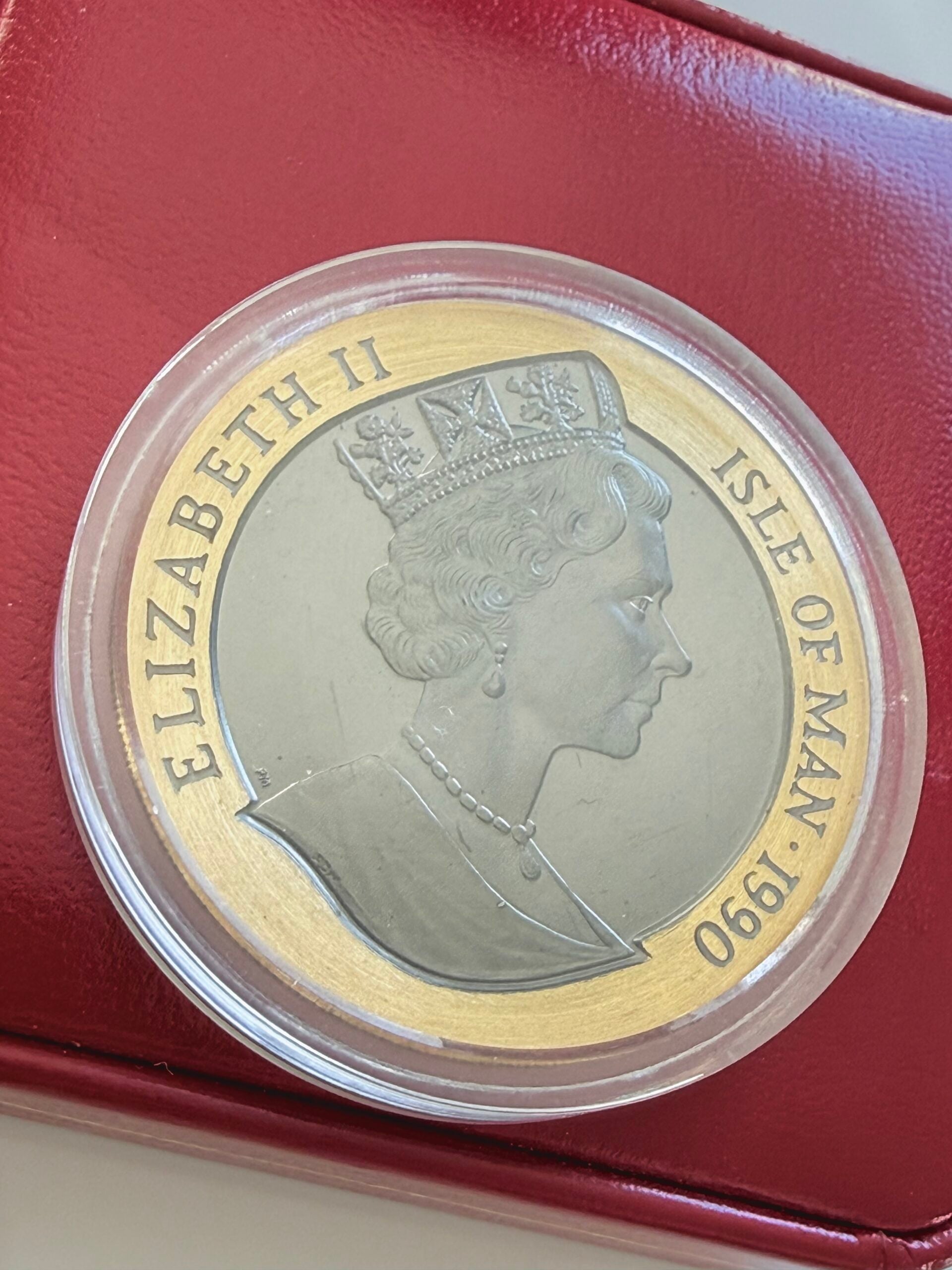 Estuche original de una moneda de oro de la Isla de Man con caja de presentación roja abierta, moneda en cápsula y certificado adjunto. La moneda lleva la inscripción “Penny Black - 150th Anniversary - Crown”, el certificado “Certificate of Proof Penny Black” y la tapa dice “Pobjoy Mint - England UK”.