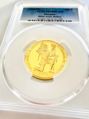 Золотая монета Панамы 1976 года, сертифицированная PCGS. На этикетке указано: "1976-FM - 500 B - PCGS PR70DCAM - Panama - 500th Anniv Balboa" и номер сертификации 141902.70/52741795. Монета сфотографирована в капсуле PCGS на белом фоне и изображает Васко Нуньеса де Бальбоа, стоящего на коленях с флагом.
