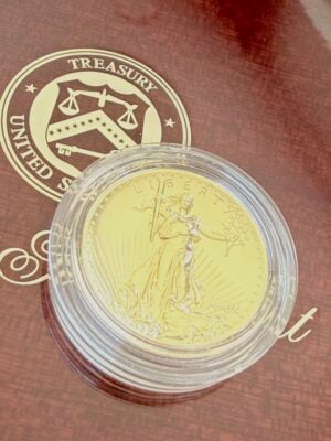 Opened original wooden presentation box from the US Mint for the 2009 Ultra High Relief Double Eagle Gold Coin. The lid bears the seal of the United States Treasury and the gold inscription "2009 Ultra High Relief Double Eagle Gold Coin". The gold coin rests in the center of the elegant wooden setting in the lower part of the box.