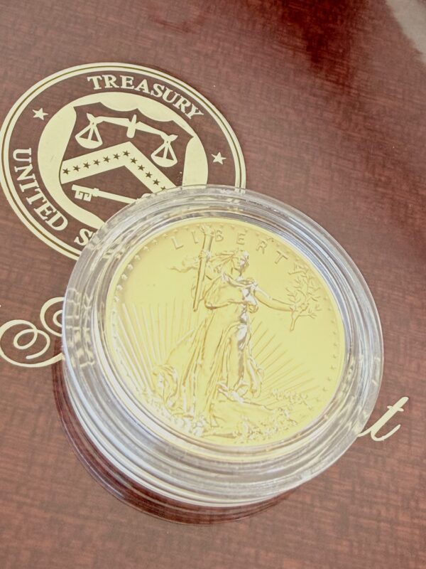 Geöffnete originale Holz-Präsentationsbox der US Mint für die 2009 Ultra High Relief Double Eagle Gold Coin. Im Deckel befinden sich das Siegel des United States Treasury sowie die goldene Aufschrift „2009 Ultra High Relief Double Eagle Gold Coin“. Im unteren Teil liegt die Goldmünze eingesetzt in der Mitte der edlen Holzfassung.